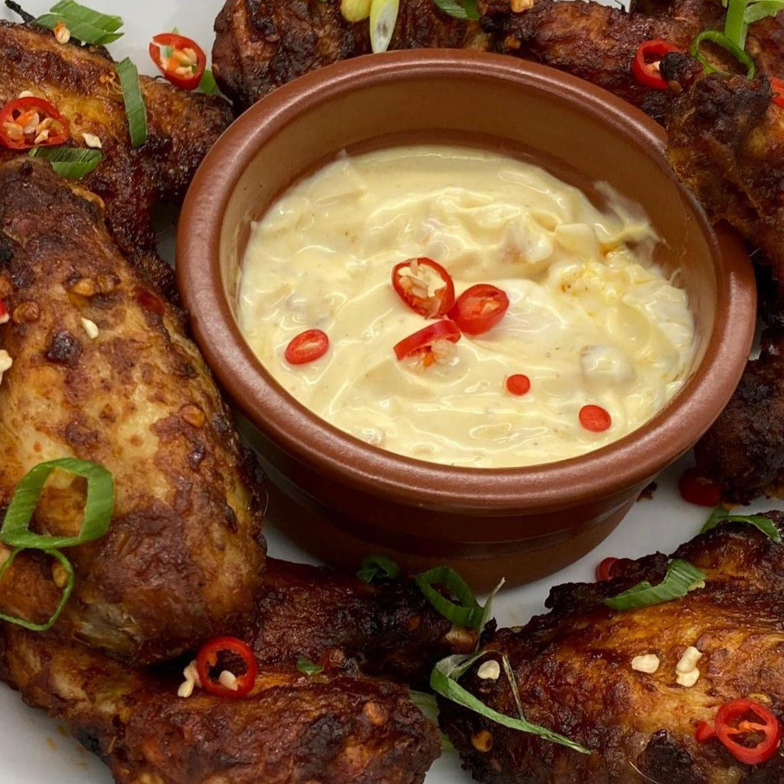 A picture of home made BBQ wings with a pot of Moruga Fire mayonnaise