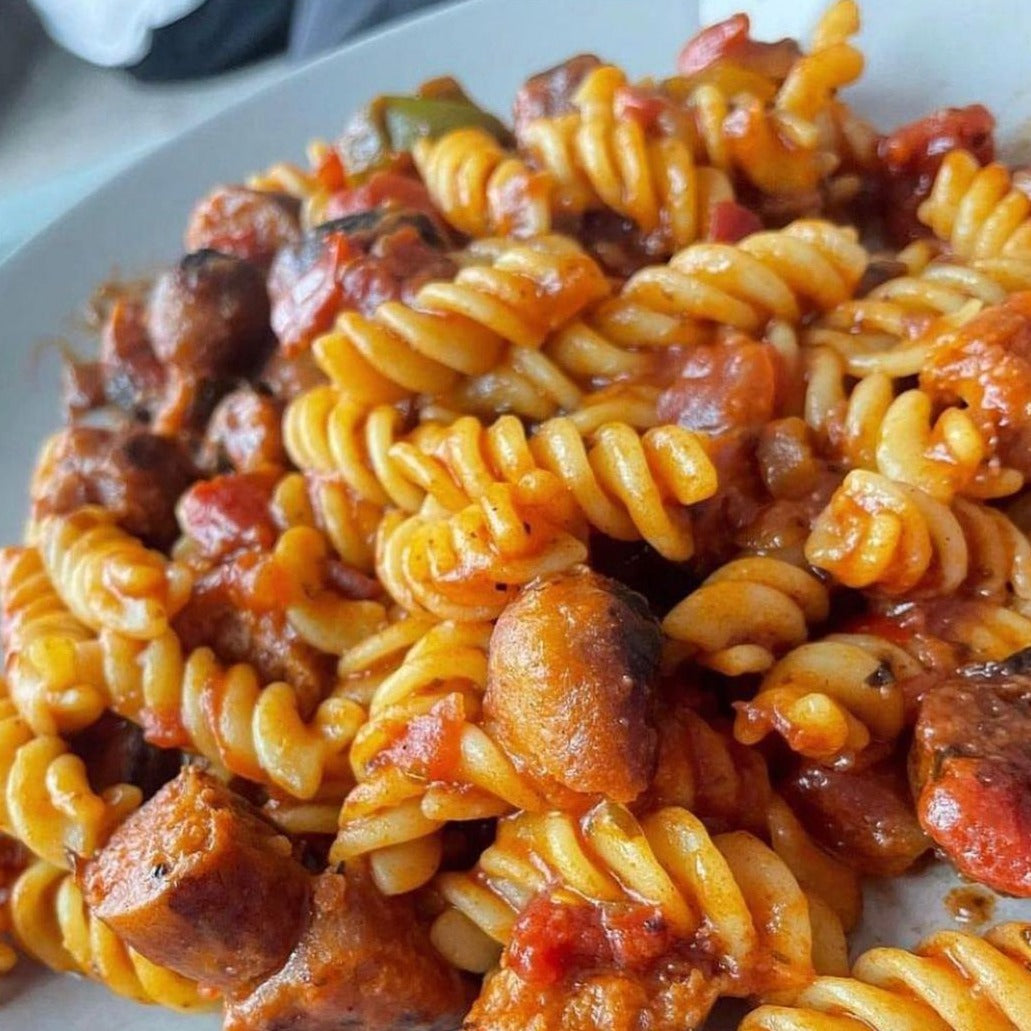 A plate of delicious sausage pasta mixed with Hot Fuzzz chilli sauce