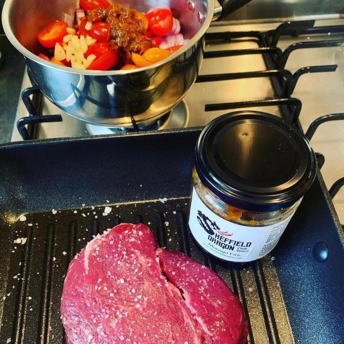 A picture of steak and vegetables being prepared with a jar of Moruga Fire chilli pickle