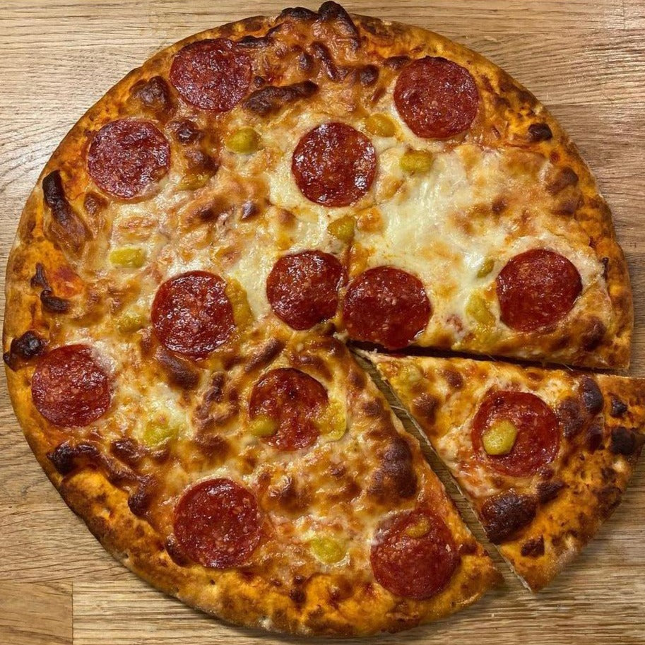 A fresh baked pizza drizzled with Renegade Mango hot sauce