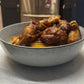 chicken wings in bowl with yellow habanero hot sauce